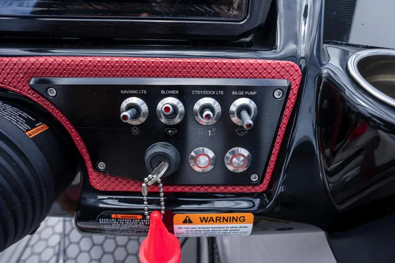 Slide: The Image of Control panel of a 2017 Scarab 255 H.O. Impulse boat with switches and warning label. - 22