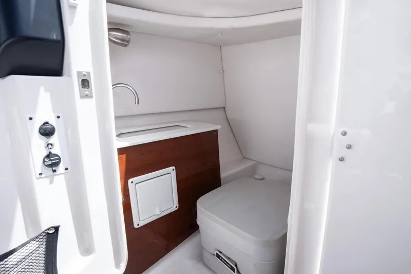 Slide: The Image of Interior of 2017 Scarab 255 H.O. Impulse boat featuring compact bathroom amenities. - 26