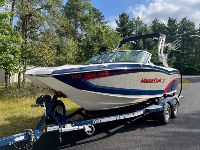 Slide: The Image of 2015 MasterCraft X20 boat on trailer outdoors. - 2