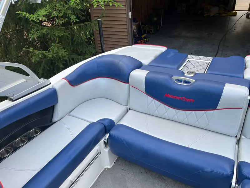 Slide: The Image of Interior of a 2015 MasterCraft X20 boat with blue and white seating. - 25