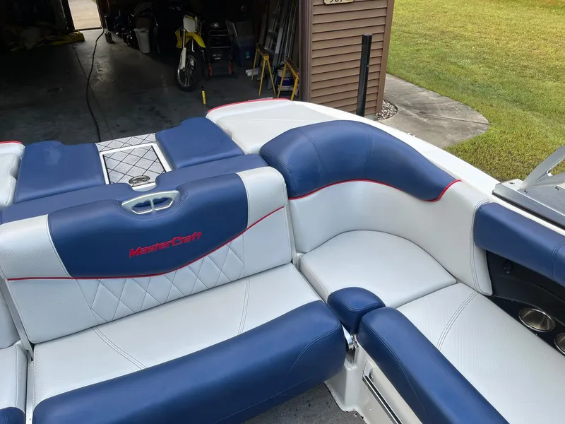 Slide: The Image of Interior of a 2015 MasterCraft X20 boat with blue and white seating. - 26