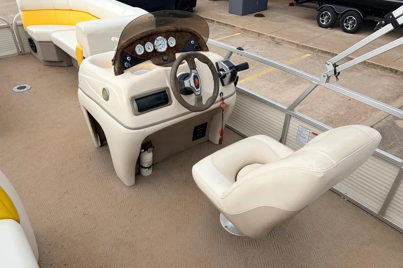 Slide: The Image of 2008 Sun Tracker Party Barge 21 Signature Series helm with beige seating and steering console. - 14