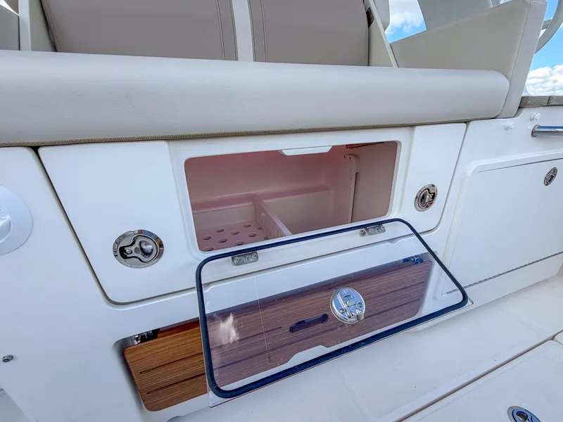 Slide: The Image of The 2027 Boston Whaler 350 Realm features an open storage compartment with a transparent door. - 15