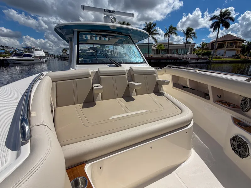 Slide: The Image of The image shows the cockpit of a 2027 Boston Whaler 350 Realm. It features beige upholstery and cup holders. - 29