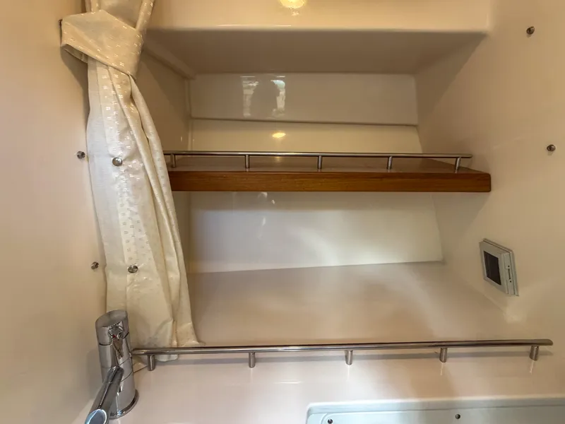 Slide: The Image of A sleek bathroom with a wooden shelf and shower curtain rod in a Boston Whaler 350 Realm. - 34