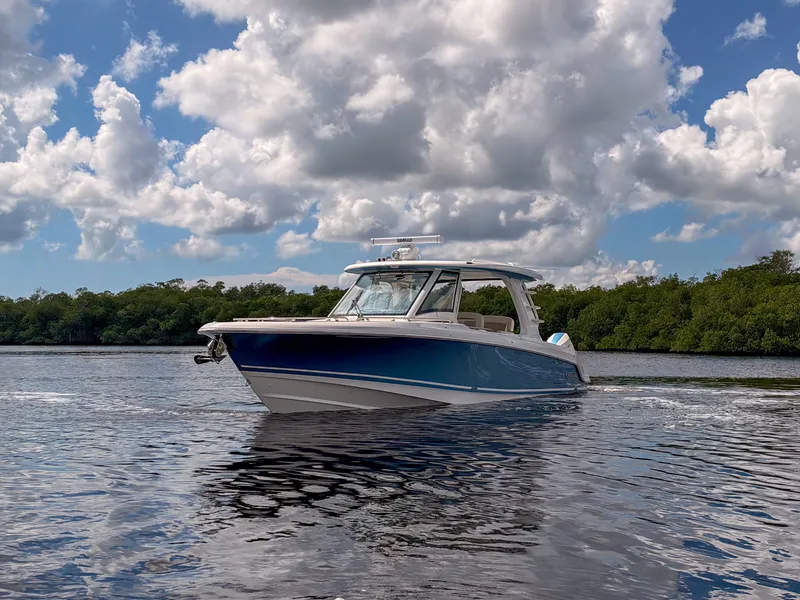 Slide: The Image of A 2027 Boston Whaler 350 Realm cruising on calm water under a cloudy sky. - 47