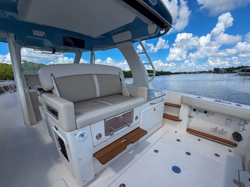 Slide: The Image of The image shows the cockpit of a 2027 Boston Whaler 350 Realm with beige seating and wood accents. - 13