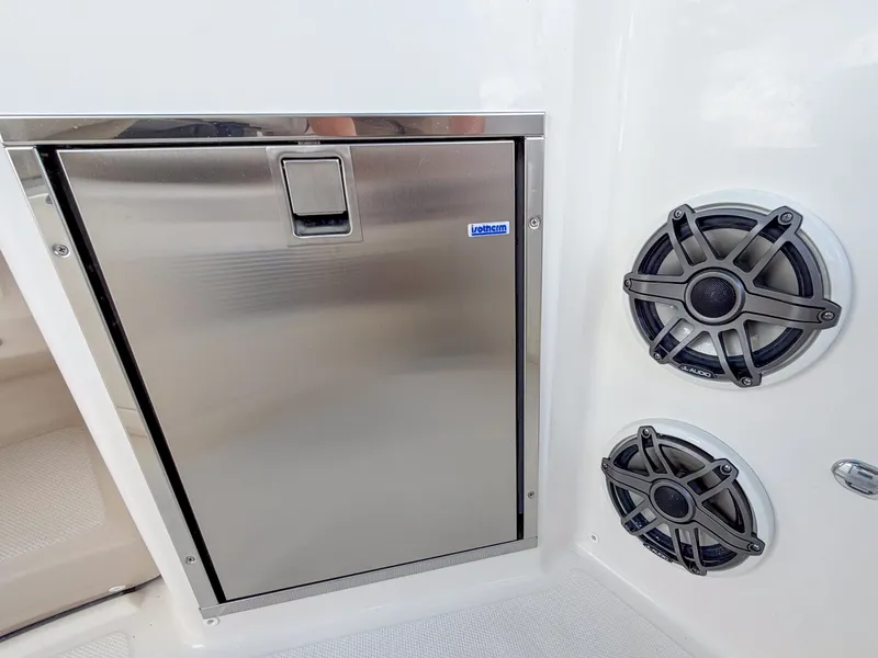 Slide: The Image of A stainless steel refrigerator next to two speakers on a boat. - 19