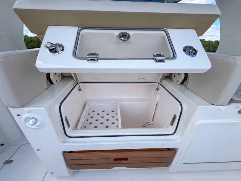 Slide: The Image of The image shows a storage compartment on a 2027 Boston Whaler 350 Realm boat. - 16