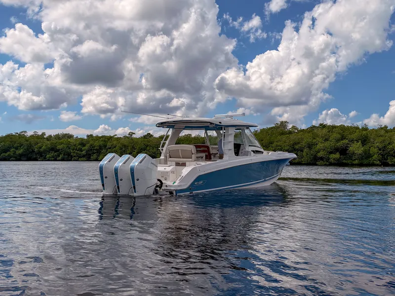 Slide: The Image of A 2027 Boston Whaler 350 Realm cruising on calm waters under a cloudy sky. - 43