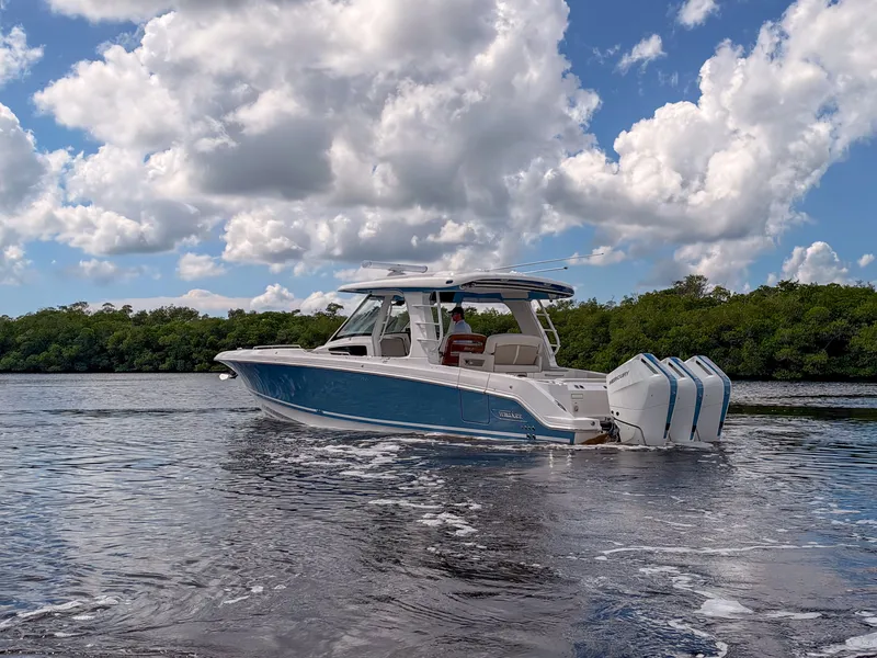 Slide: The Image of A 2027 Boston Whaler 350 Realm cruising on calm waters under a cloudy sky. - 45