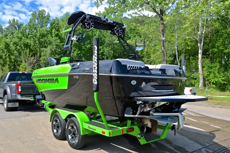 Slide: The Image of 2024 Moomba Mondo boat on trailer, vibrant green and black design, parked outdoors. - 12