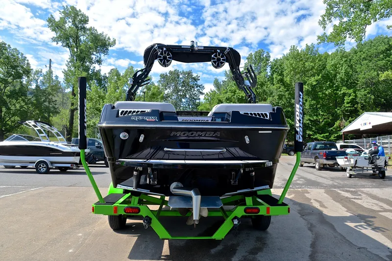 Slide: The Image of 2024 Moomba Mondo boat on a vibrant green trailer, parked outdoors. - 13