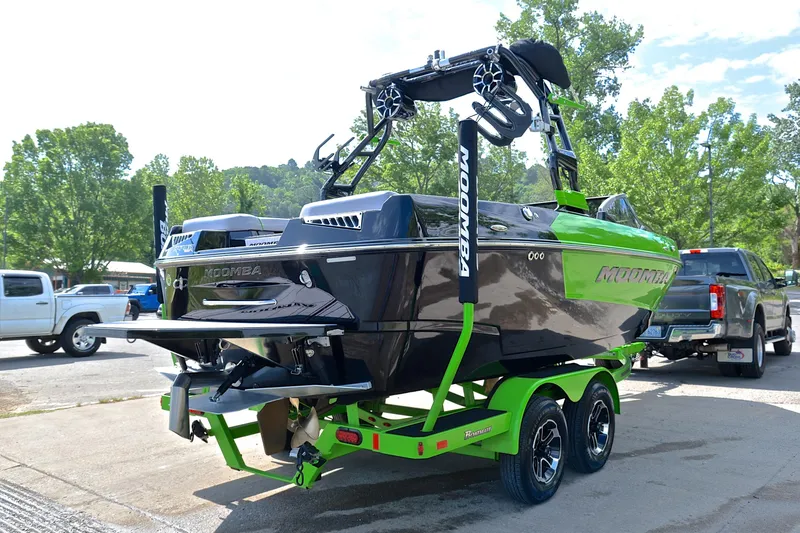 Slide: The Image of 2024 Moomba Mondo boat on trailer, vibrant green and black design, parked outdoors. - 14