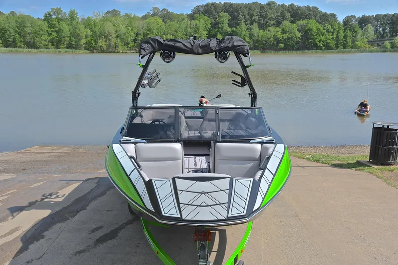 Slide: The Image of 2024 Moomba Mondo boat at a lakeside launch, featuring vibrant green accents. - 17