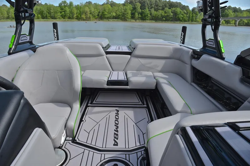 Slide: The Image of 2024 Moomba Mondo boat interior with sleek gray seating and modern design on a serene lake. - 22
