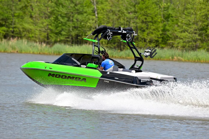 Slide: The Image of 2024 Moomba Mondo boat speeding on a lake, vibrant green and black design. - 4