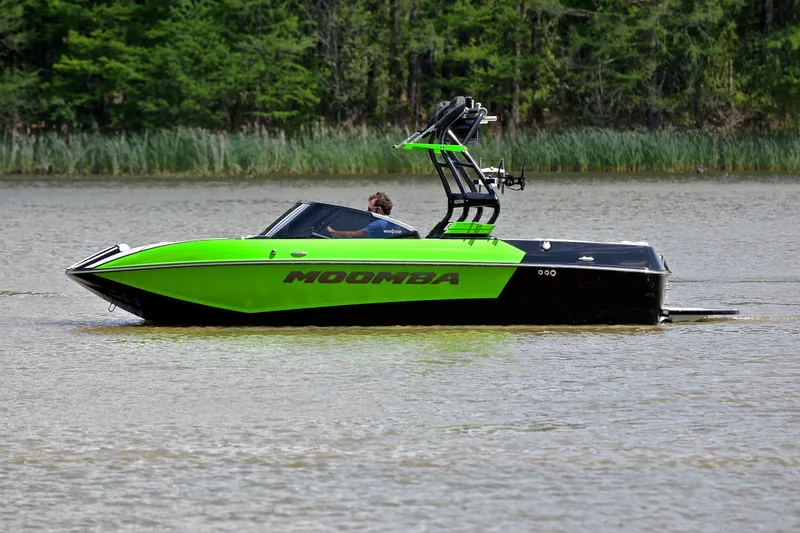 Slide: The Image of 2024 Moomba Mondo boat in vibrant green on a calm lake. - 9