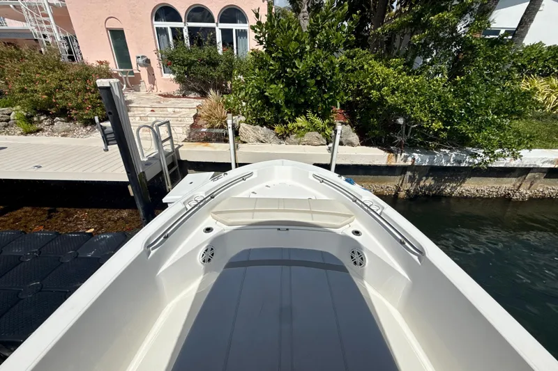 Slide: The Image of 2023 Boston Whaler 220 Dauntless boat docked near a waterfront home. - 11