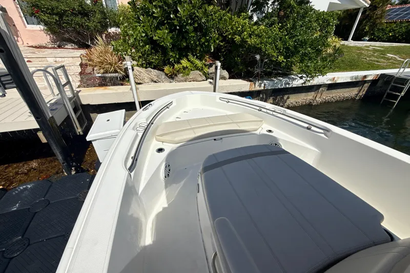 Slide: The Image of 2023 Boston Whaler 220 Dauntless boat docked, featuring spacious seating and sleek design. - 12