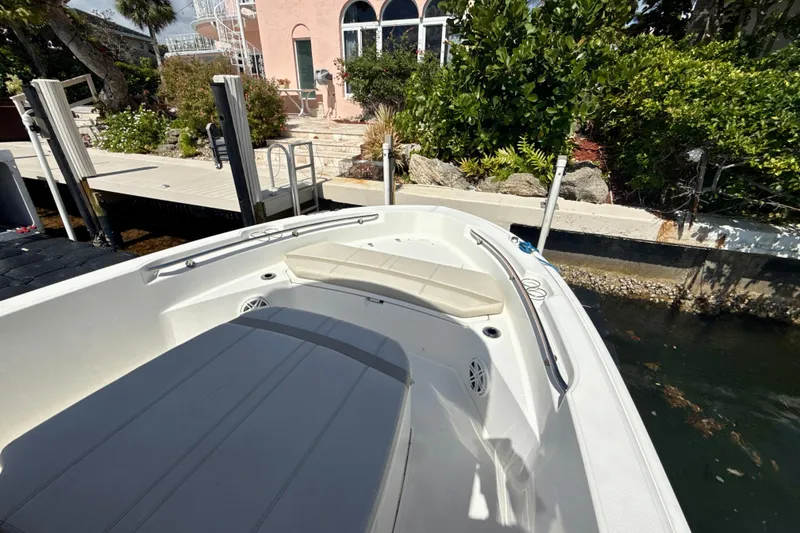 Slide: The Image of 2023 Boston Whaler 220 Dauntless boat docked near lush garden and waterfront home. - 13