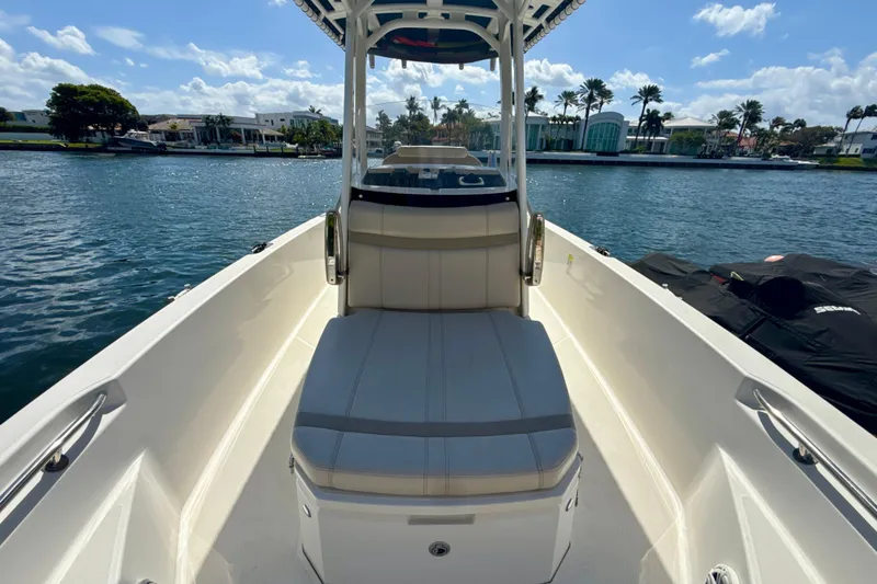 Slide: The Image of 2023 Boston Whaler 220 Dauntless boat on calm water, showcasing seating and sleek design. - 14