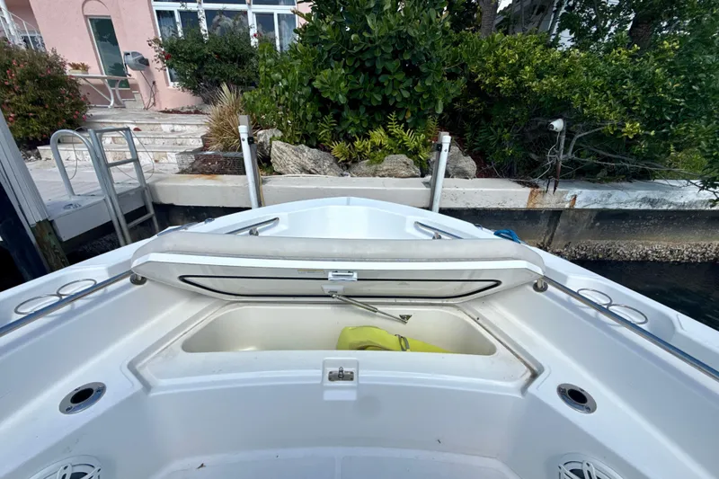 Slide: The Image of 2023 Boston Whaler 220 Dauntless boat with open storage compartment at dockside. - 17