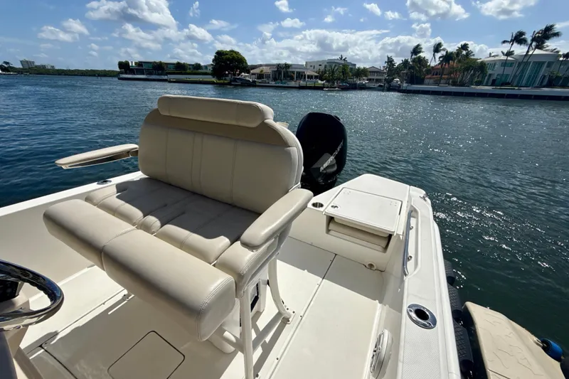 Slide: The Image of 2023 Boston Whaler 220 Dauntless boat interior with seating, on a sunny waterfront. - 21