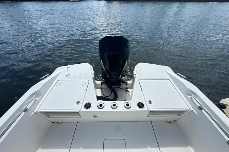 Slide: The Image of 2023 Boston Whaler 220 Dauntless boat stern view with outboard motor on water. - 5