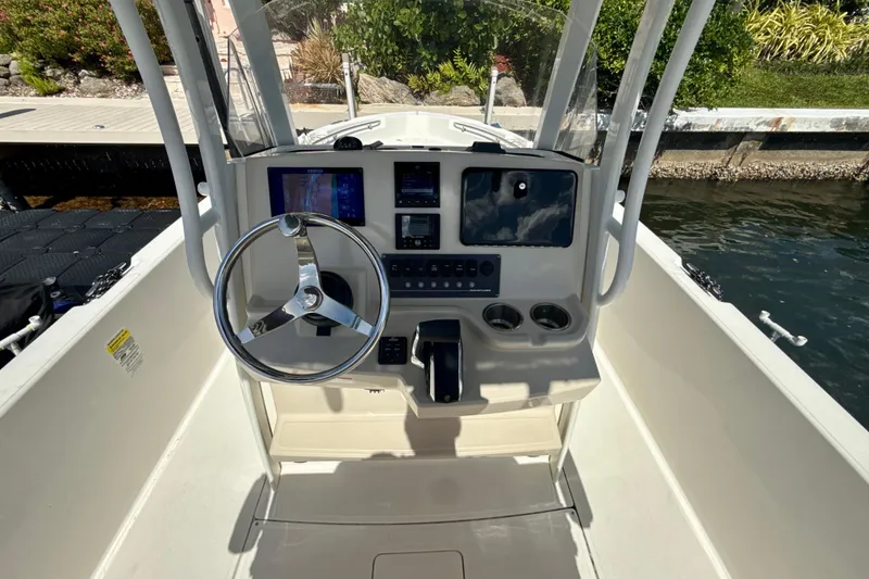 Slide: The Image of 2023 Boston Whaler 220 Dauntless helm with steering wheel and navigation controls. - 8