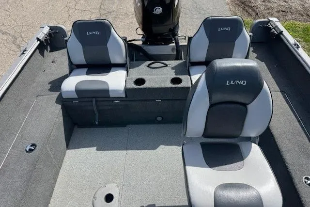 Slide: The Image of 2011 Lund 1875 Impact SS boat interior with three gray seats and motor. - 12