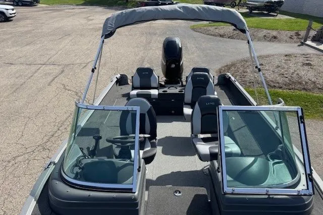 Slide: The Image of 2011 Lund 1875 Impact SS boat with open seating and windshield, parked on pavement. - 17