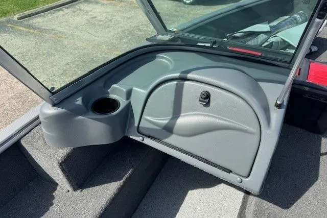 Slide: The Image of 2011 Lund 1875 Impact SS boat interior with open storage compartment and cup holder. - 18