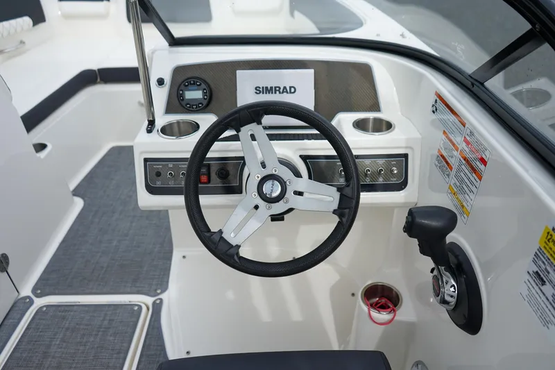 Slide: The Image of Cockpit of 2020 Bayliner DX 2200 boat with steering wheel and control panel. - 10