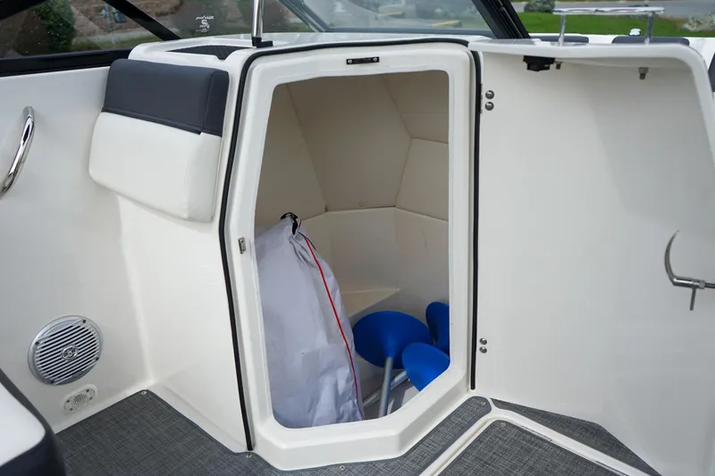 Slide: The Image of 2020 Bayliner DX 2200 boat interior storage compartment with seating and accessories. - 16