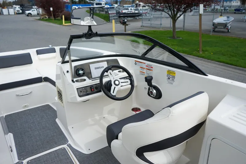 Slide: The Image of 2020 Bayliner DX 2200 boat cockpit with steering wheel and control panel. - 9
