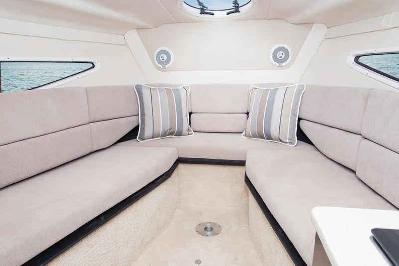 Slide: The Image of Manufacturer Provided Image: 2025 Regal 26 Express cabin interior with plush seating and striped cushions. - 11