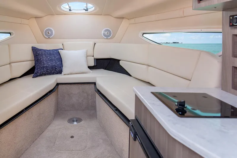 Slide: The Image of Manufacturer Provided Image: Interior of 2025 Regal 26 Express boat with beige seating and compact kitchen area. - 14