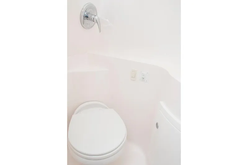 Slide: The Image of Manufacturer Provided Image: 2025 Regal 26 Express boat bathroom with white toilet and chrome fixtures. - 15