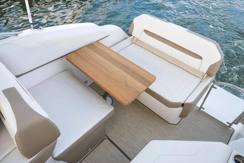 Slide: The Image of Manufacturer Provided Image: 2025 Regal 26 Express boat interior with cushioned seating and wooden table. - 9