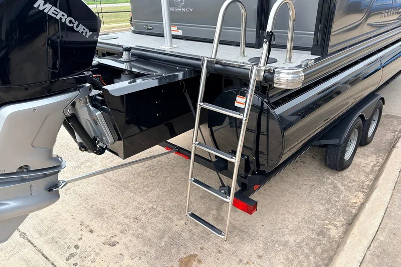 Slide: The Image of 2022 Regency 250 DL3 pontoon boat with Mercury engine and boarding ladder on trailer. - 10