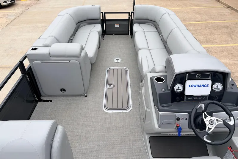 Slide: The Image of 2022 Regency 250 DL3 pontoon boat interior with gray seating and modern dashboard. - 12
