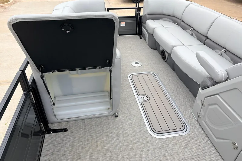 Slide: The Image of 2022 Regency 250 DL3 boat interior with open storage compartment and plush seating. - 14