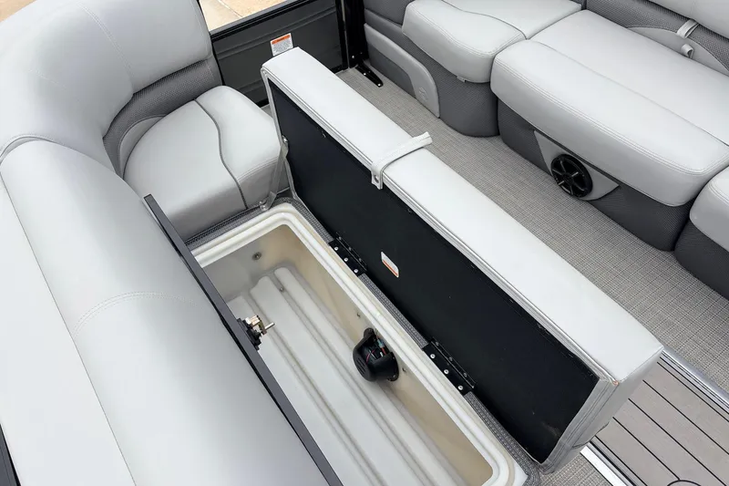 Slide: The Image of 2022 Regency 250 DL3 boat interior with open storage compartment and cushioned seating. - 16