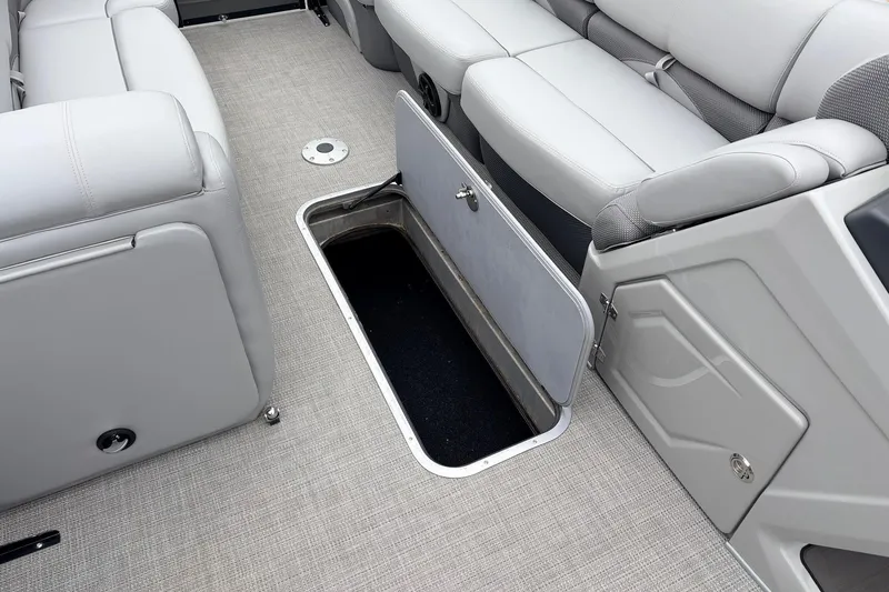 Slide: The Image of 2022 Regency 250 DL3 boat interior with open storage compartment and gray seating. - 29
