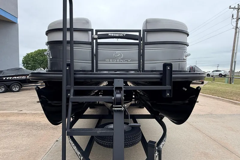 Slide: The Image of 2022 Regency 250 DL3 pontoon boat on trailer, rear view in outdoor setting. - 3