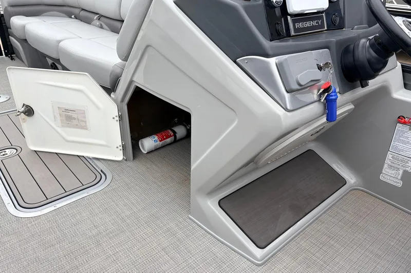 Slide: The Image of 2022 Regency 250 DL3 boat interior with open storage compartment and safety equipment. - 32