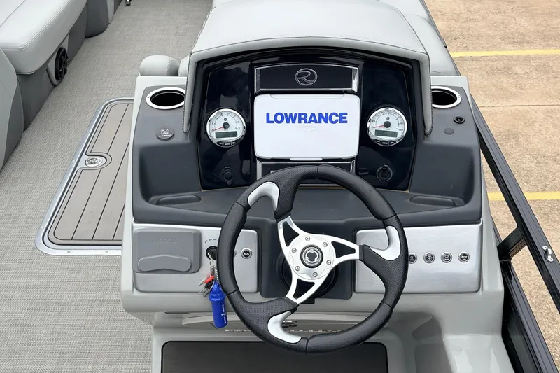 Slide: The Image of 2022 Regency 250 DL3 boat dashboard with steering wheel and Lowrance display. - 33