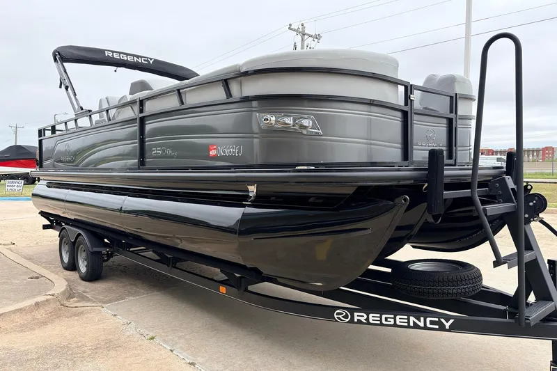 Slide: The Image of 2022 Regency 250 DL3 pontoon boat on trailer, sleek design, gray and black color scheme. - 4