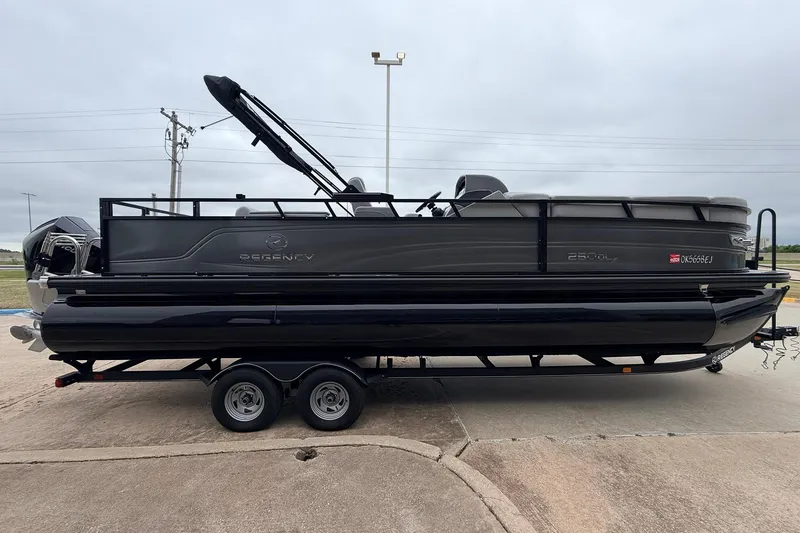 Slide: The Image of 2022 Regency 250 DL3 pontoon boat on trailer, parked outdoors. - 5